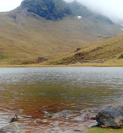 Brujo de Huancabamba revelando secretos de la brujería junto a una laguna sagrada.